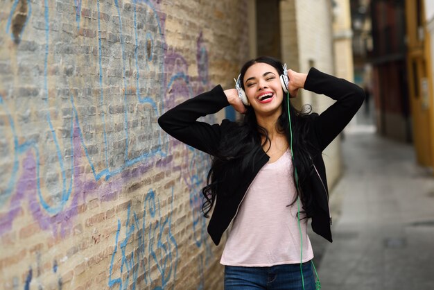 Adolescente escuchando música con auriculares al aire libre