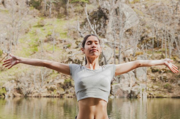 Adolescente estirando sus brazos con los ojos cerrados