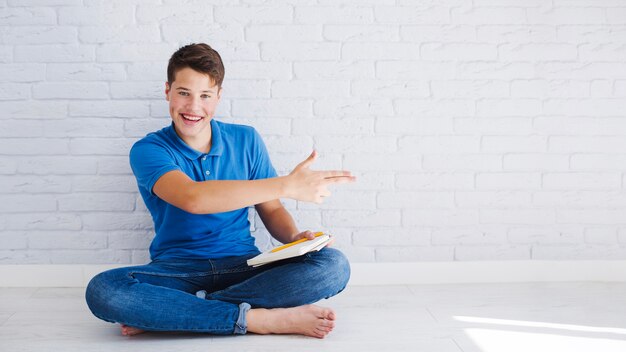 Adolescente feliz apuntando hacia la derecha