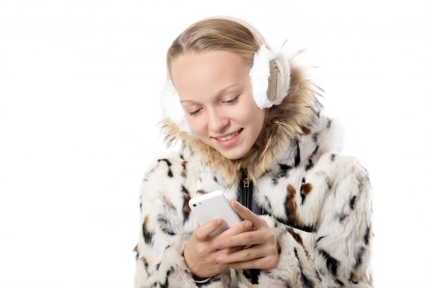 Adolescente feliz con orejeras usando su móvil