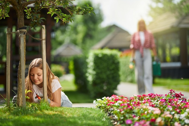 Adolescente femenina y su madre cuidando las plantas del patio trasero