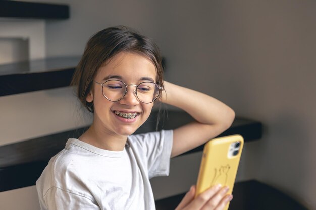 Una adolescente con gafas y aparatos ortopédicos se comunica a través de una llamada de video