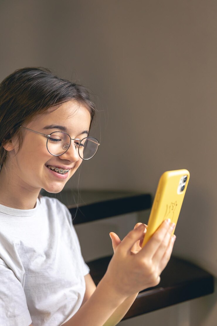 Foto gratuito una adolescente con gafas y aparatos ortopédicos se comunica a través de una llamada de video