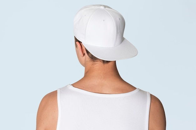 Adolescente con gorra blanca snapback y camiseta sin mangas street fashion shoot vista trasera