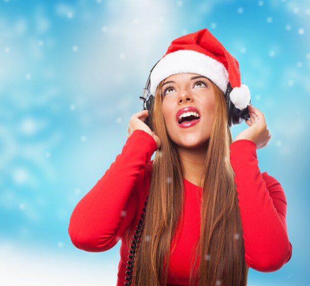 Foto gratuita adolescente con gorro de santa escuchando música