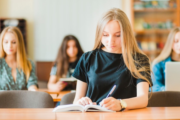 Adolescente haciendo notas durante la lección