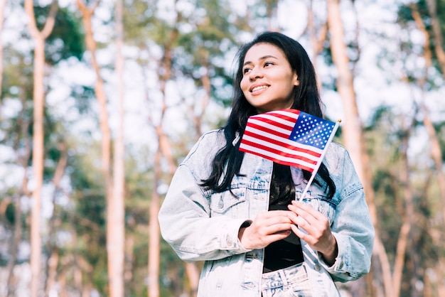 Adolescente hispana, tenencia, bandera estadounidense, en, palo