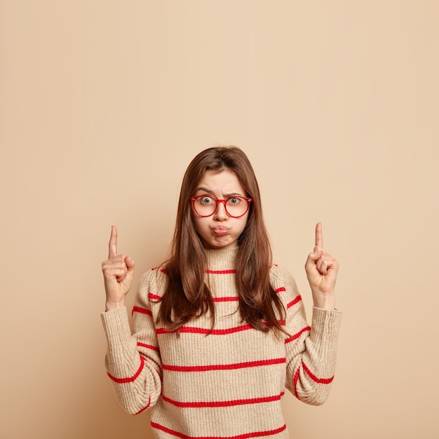 Foto gratuita adolescente de jengibre con anteojos rojos