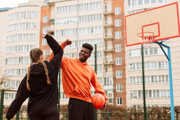 Foto gratuita adolescente jugando baloncesto juntos