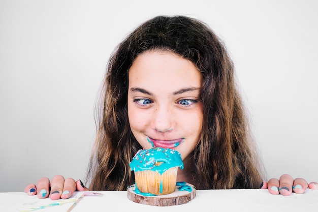 Adolescente lamiendo los labios después de comer muffin