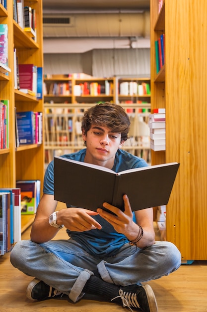 Adolescente leyendo en el piso