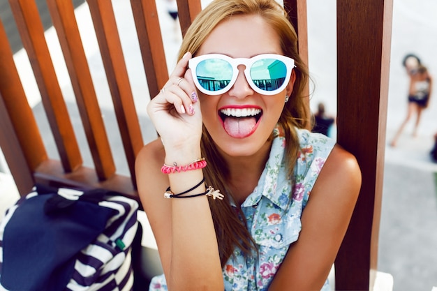 Foto gratuita adolescente llevando gafas de sol y poniendo cara graciosa