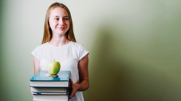 Adolescente con manzana y libros