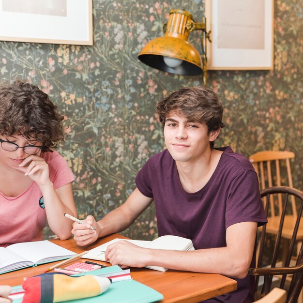 Adolescente masculino haciendo la tarea con un amigo