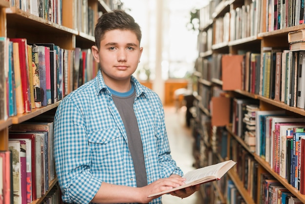 Adolescente masculino con libro abierto