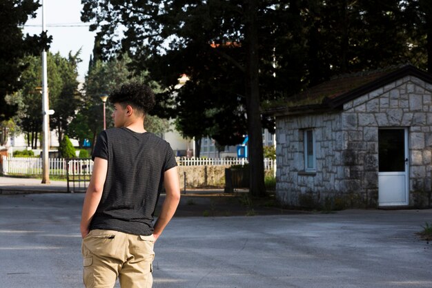 Adolescente masculino de pie y soñando despierto en la calle