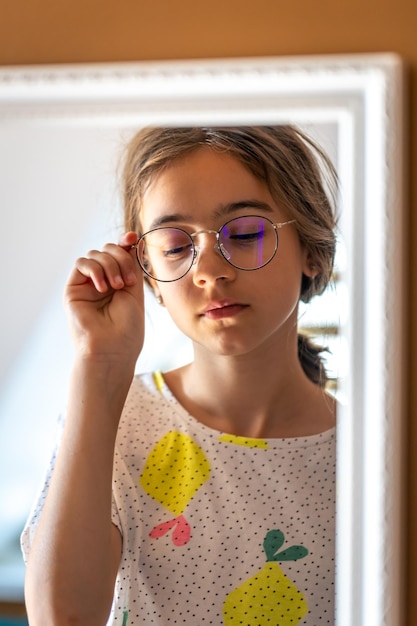 Foto gratuita una adolescente se mira en el espejo por la mañana.