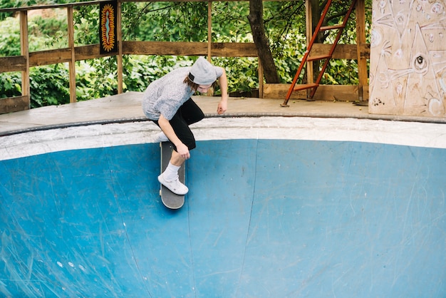 Adolescente montando skateboard por rampa