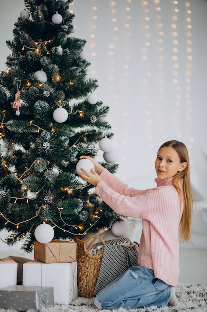 Adolescente niña decorar el árbol de navidad