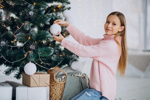 Adolescente niña decorar el árbol de navidad