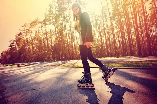 Adolescente en patines de ruedas en el verano.