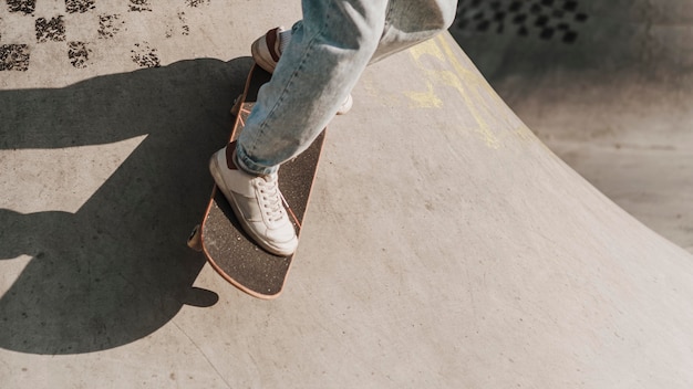 Adolescente con patineta divirtiéndose en el skatepark y copie el espacio