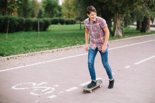 Adolescente en patineta junto al carril bici