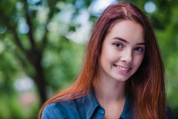 Adolescente pelirroja chica sonriendo fuera