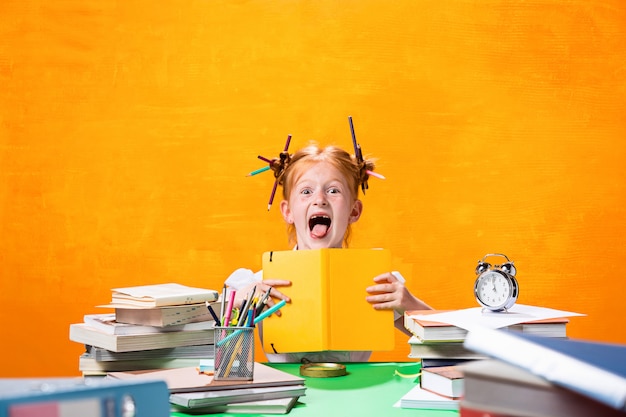 La adolescente pelirroja con muchos libros en casa. Tiro del estudio