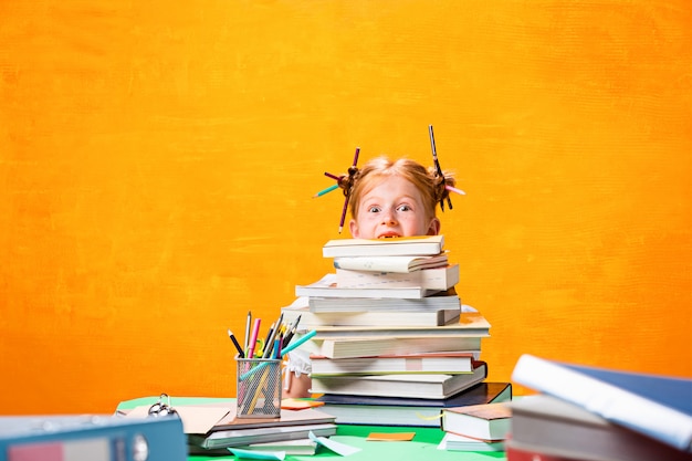 La adolescente pelirroja con muchos libros en casa.