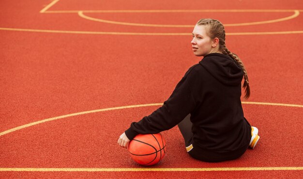 Adolescente posando en el campo de baloncesto