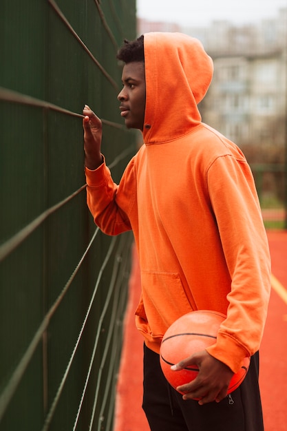 Foto gratuita adolescente posando en el campo de baloncesto