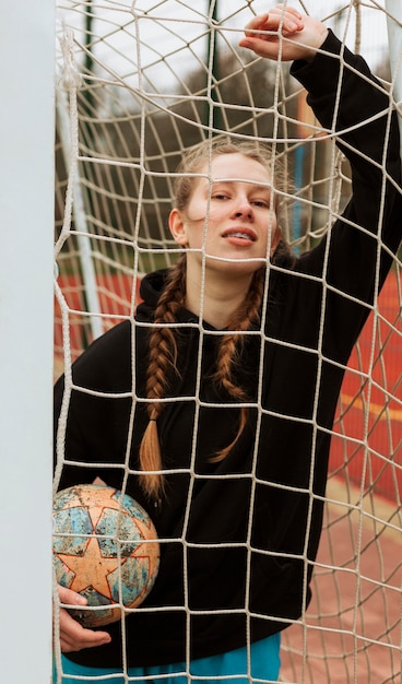 Adolescente posando con una pelota al aire libre