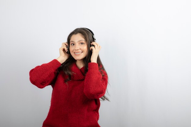 Adolescente positivo escucha música en auriculares estéreo.