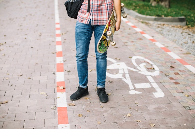 Foto gratuita adolescente que se coloca en carril de la bici con el patín