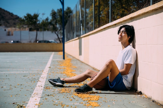 Adolescente relajante en el campo de baloncesto