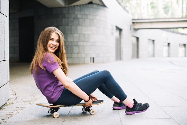 Adolescente riendo en patineta