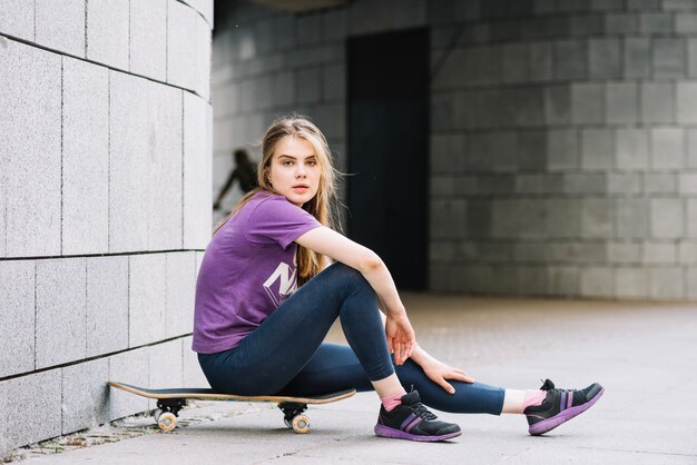 Adolescente sentado en patineta