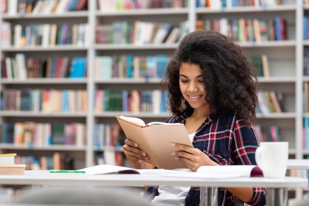 Adolescente sonriente de alto ángulo en la biblioteca