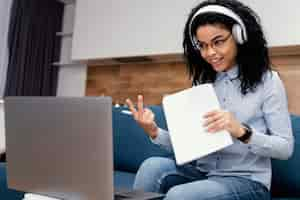 Foto gratuita adolescente sonriente con auriculares durante la escuela en línea