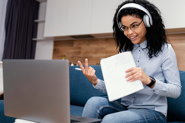 Adolescente sonriente con auriculares durante la escuela en línea