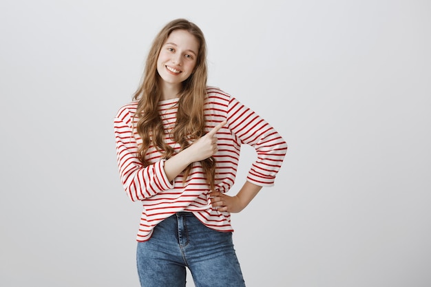 Foto gratuita adolescente sonriente dedo acusador en la esquina superior derecha