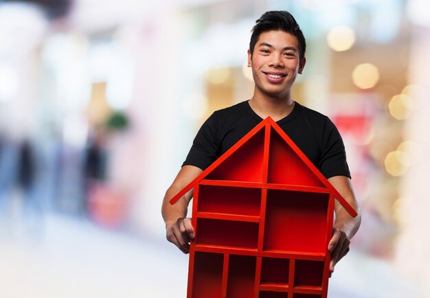 Adolescente sonriente con su casa de madera