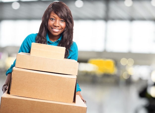 Adolescente sonriente sujetando cajas de cartón