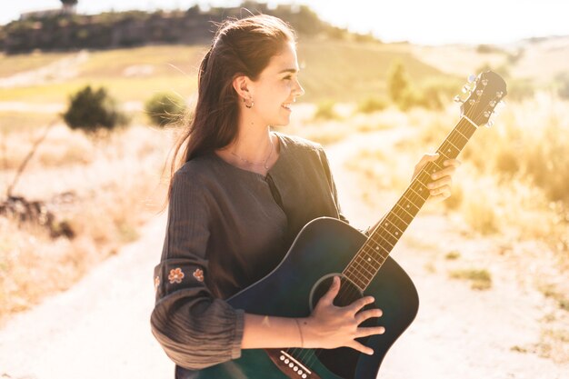 Adolescente sonriente tocando la guitarra