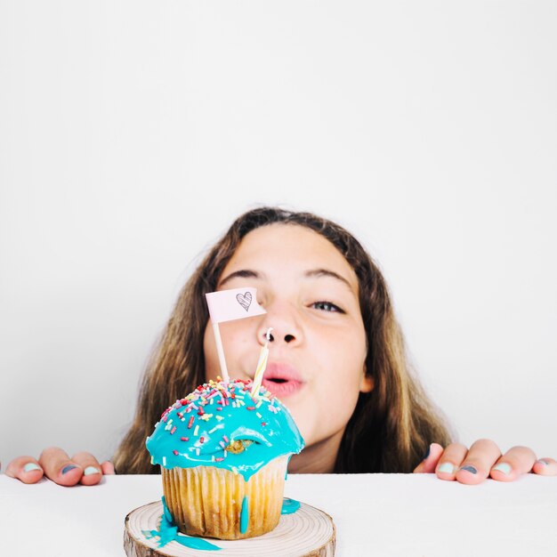 Adolescente, soplar, vela, en, cupcake