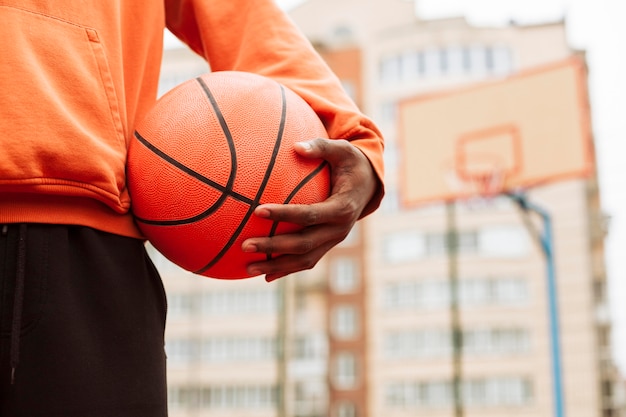 Foto gratuita adolescente sosteniendo el baloncesto al aire libre