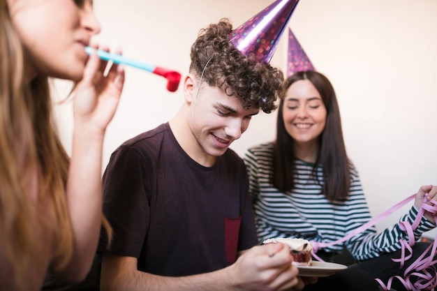 Adolescente con tarta de queso con amigos