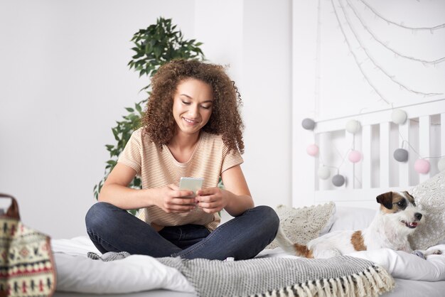 Adolescente mediante teléfono móvil en su dormitorio