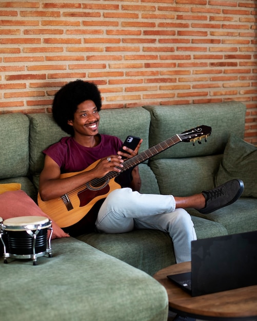 Adolescente de tiro completo haciendo música en casa